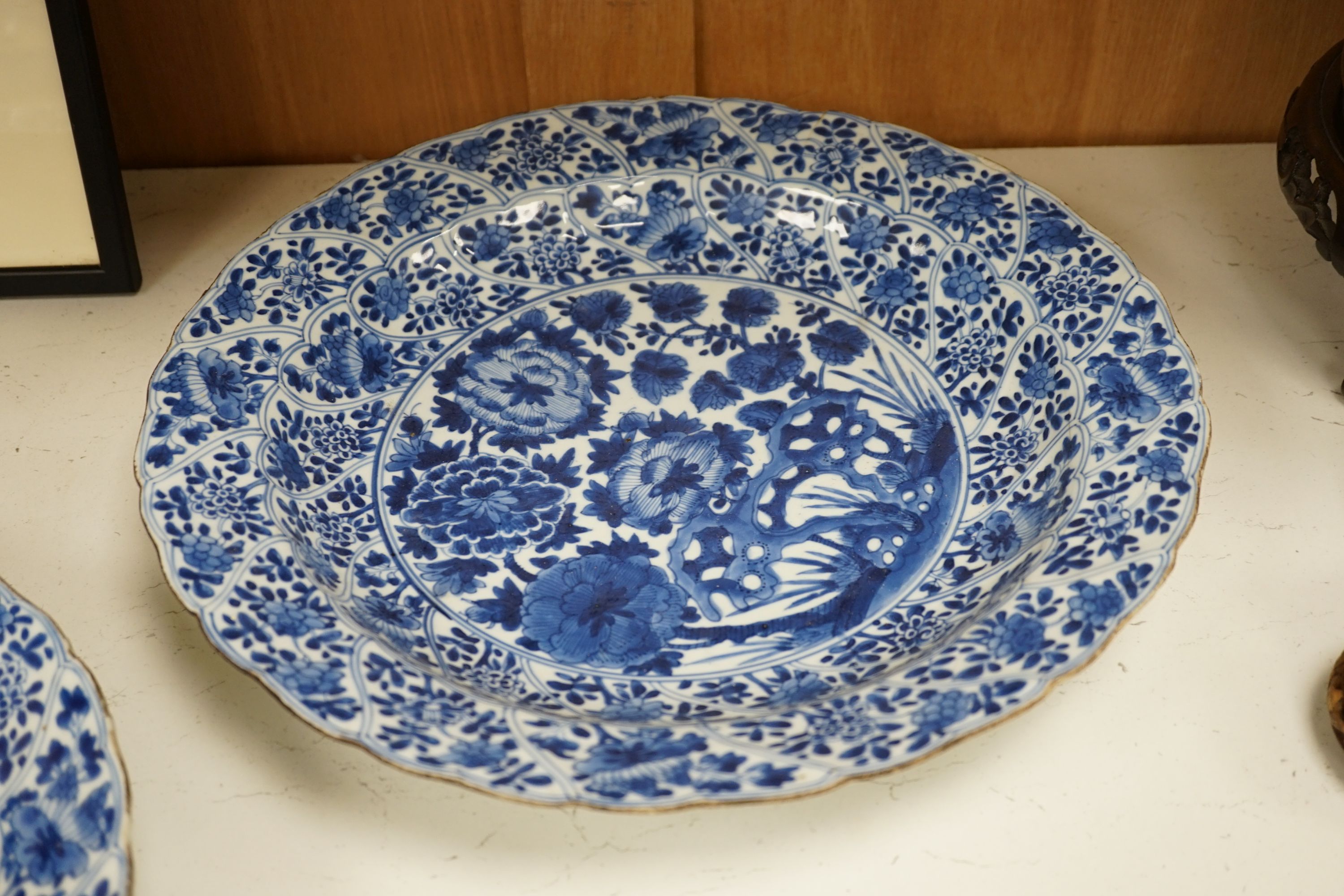 A pair of Chinese Kangxi blue and white dishes, painted with rock work and flowers, artemisia leaf marks, 37cm diameter